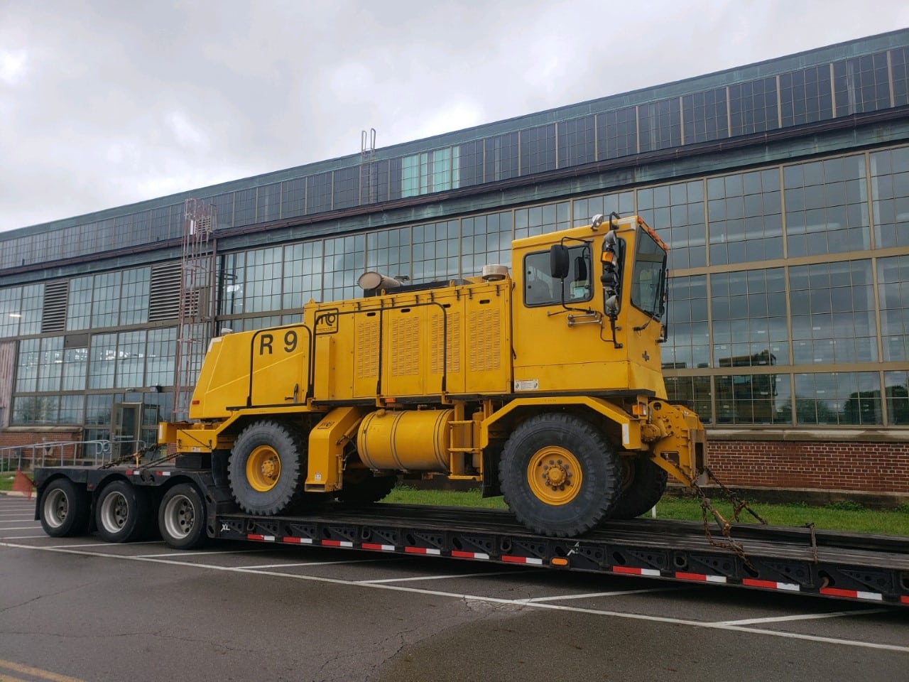 Transporting an Oshkosh airport plow on a lowboy trailer