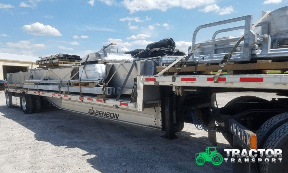 Milking stalls disassembled and loaded for transport on a step deck trailer