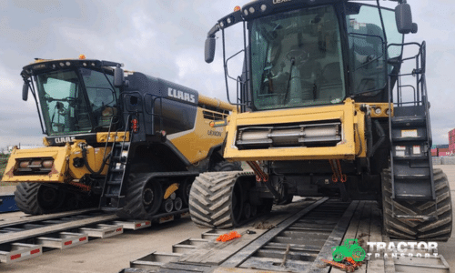Two Claas combines loaded for transport on lowboy trailers