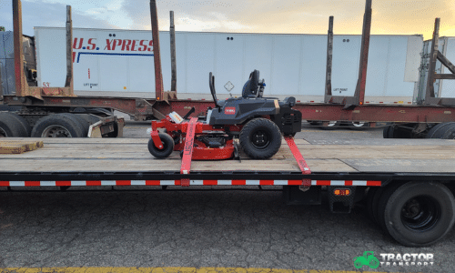 shipping a red mower on a flatbed trailer