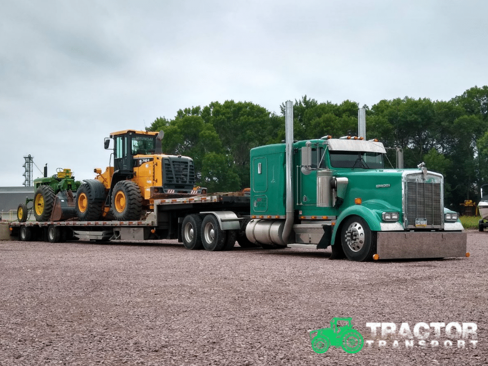 Kenworth semi truck hauling farm equipment and wheel loader on flatbed trailer for tractor transport service