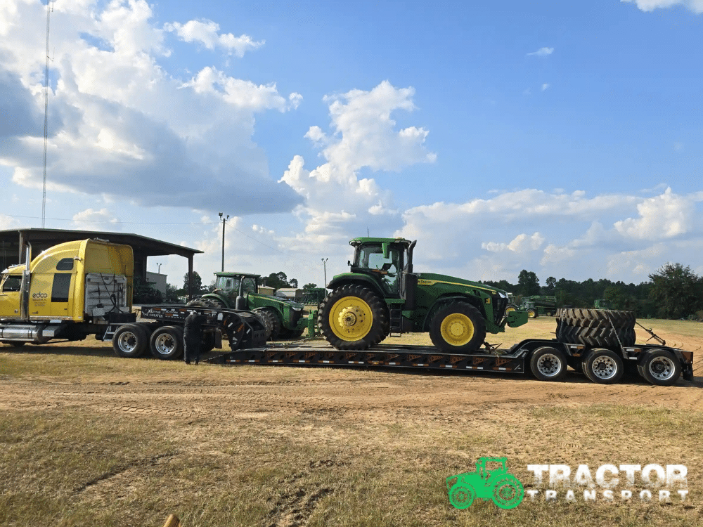 Two large John Deere tractors loaded on step-deck trailer for heavy equipment transport by Tractor Transport