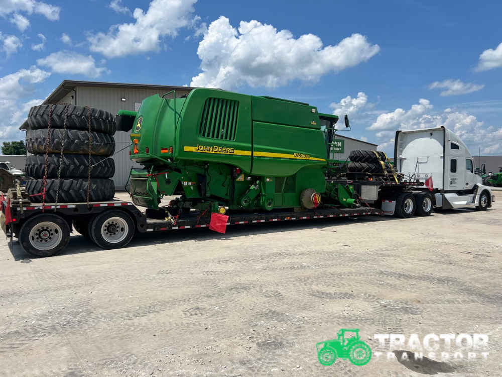 John Deere 9750 STS combine being transported on a specialized trailer for farm equipment shipping services in Thornton, CO